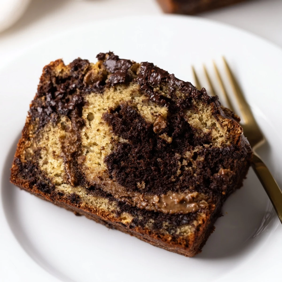 Homemade chocolate peanut butter banana bread with golden crust, peanut butter swirls, and chocolate chip chunks visible