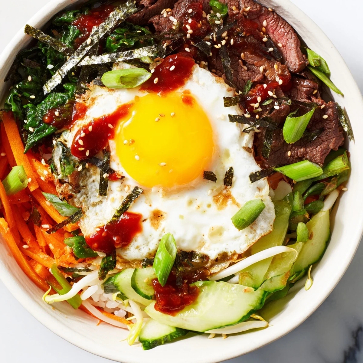 Korean-inspired breakfast bowl topped with fried egg and spicy gochujang sauce
