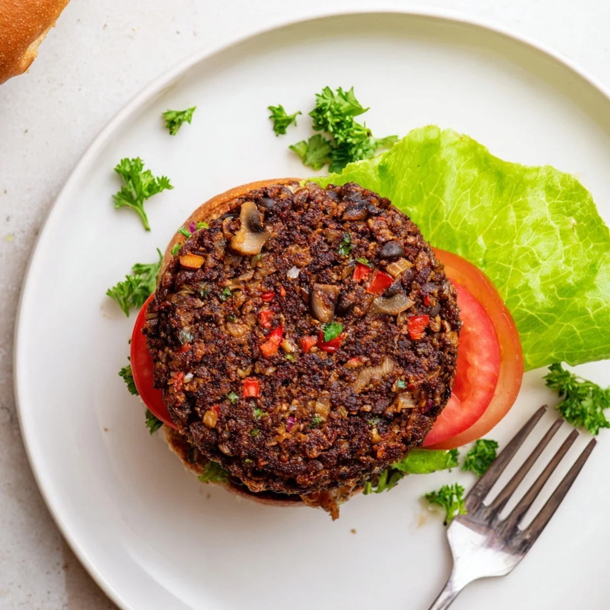 Meatless mushroom veggie burger topped with crisp vegetables and served on a sesame seed bun