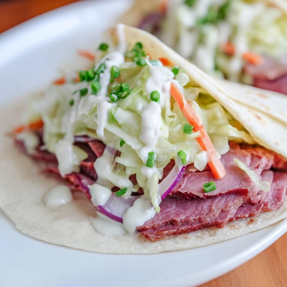 Warm flour tortillas filled with sliced corned beef and tangy cabbage slaw