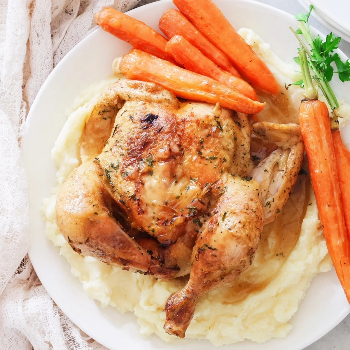Comforting homemade dinner featuring herb seasoned chicken with creamy potatoes and tender honey coated carrots arranged on serving dish