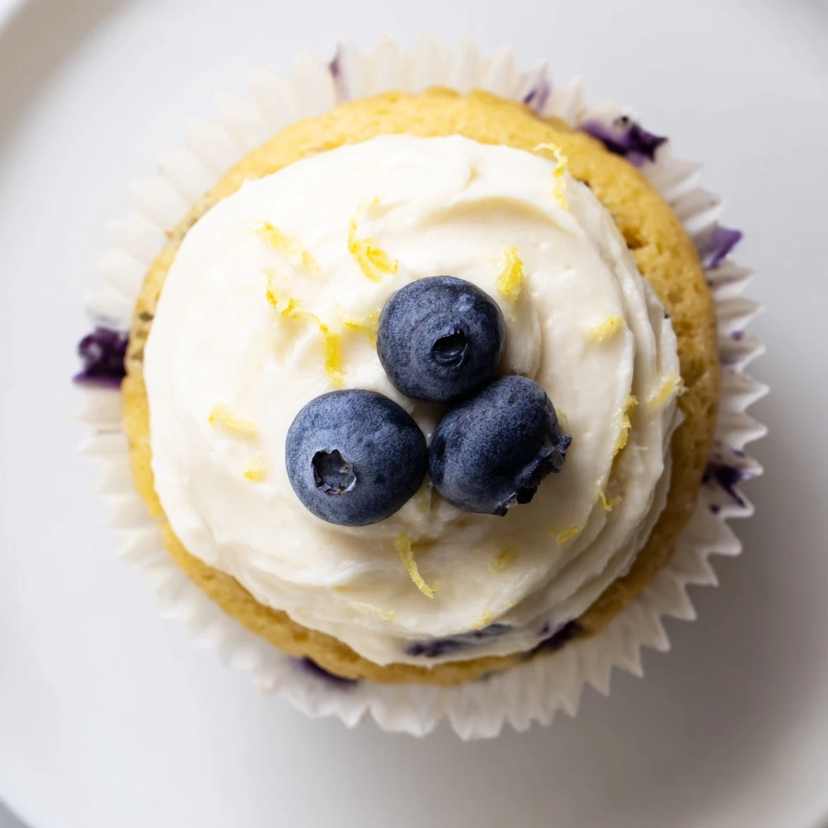 Fluffy lemon blueberry cupcakes topped with tangy cream cheese frosting and fresh blueberry garnish