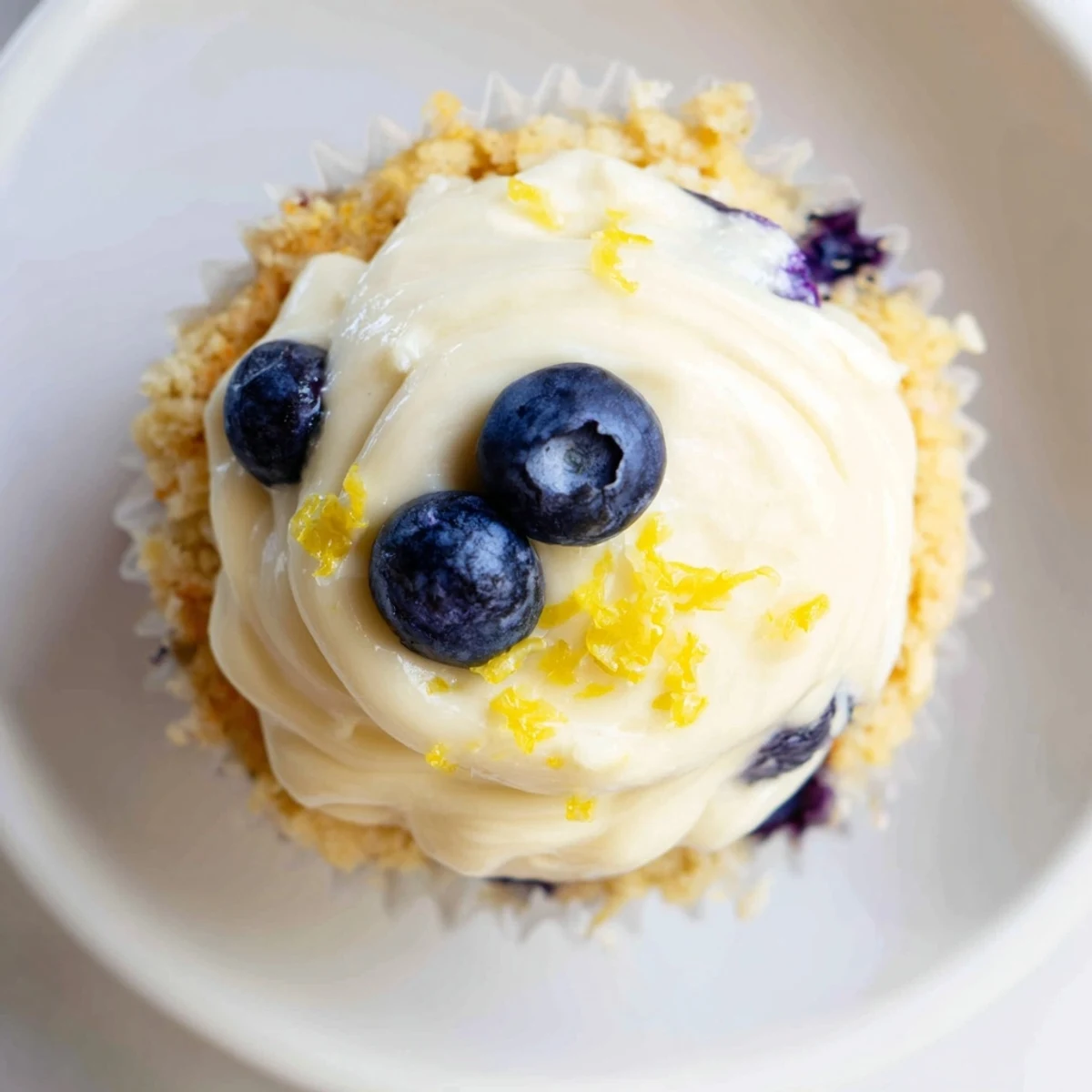 Light and airy lemon blueberry cupcakes burst with fresh fruit beneath zesty lemon frosting