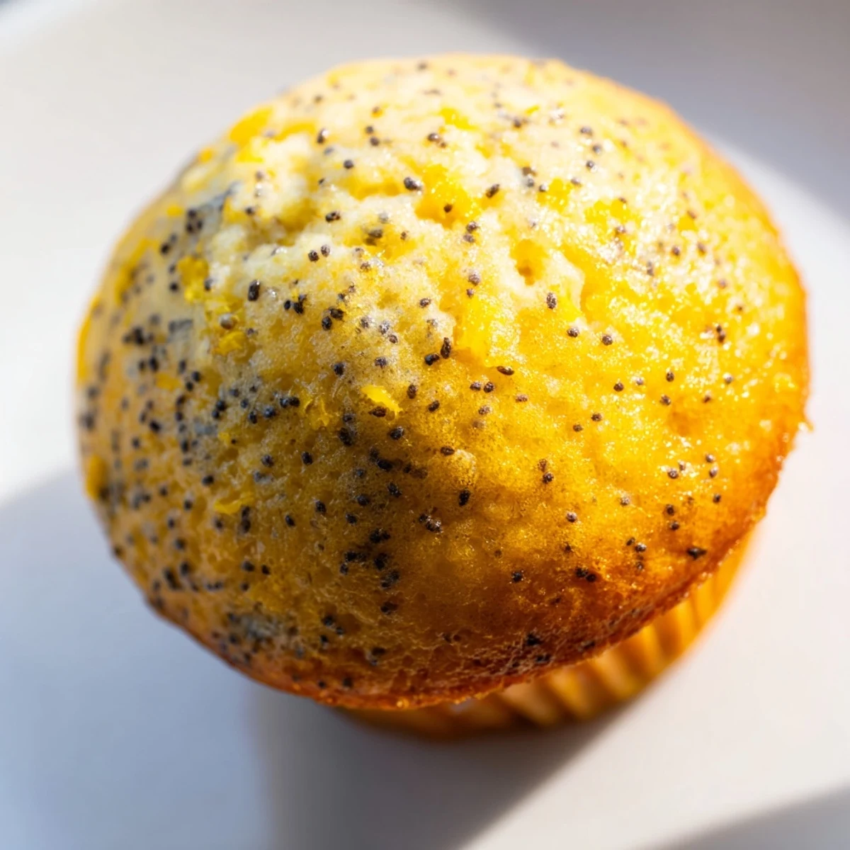 Golden lemon poppy seed muffins with domed tops fresh from the oven on a wire cooling rack