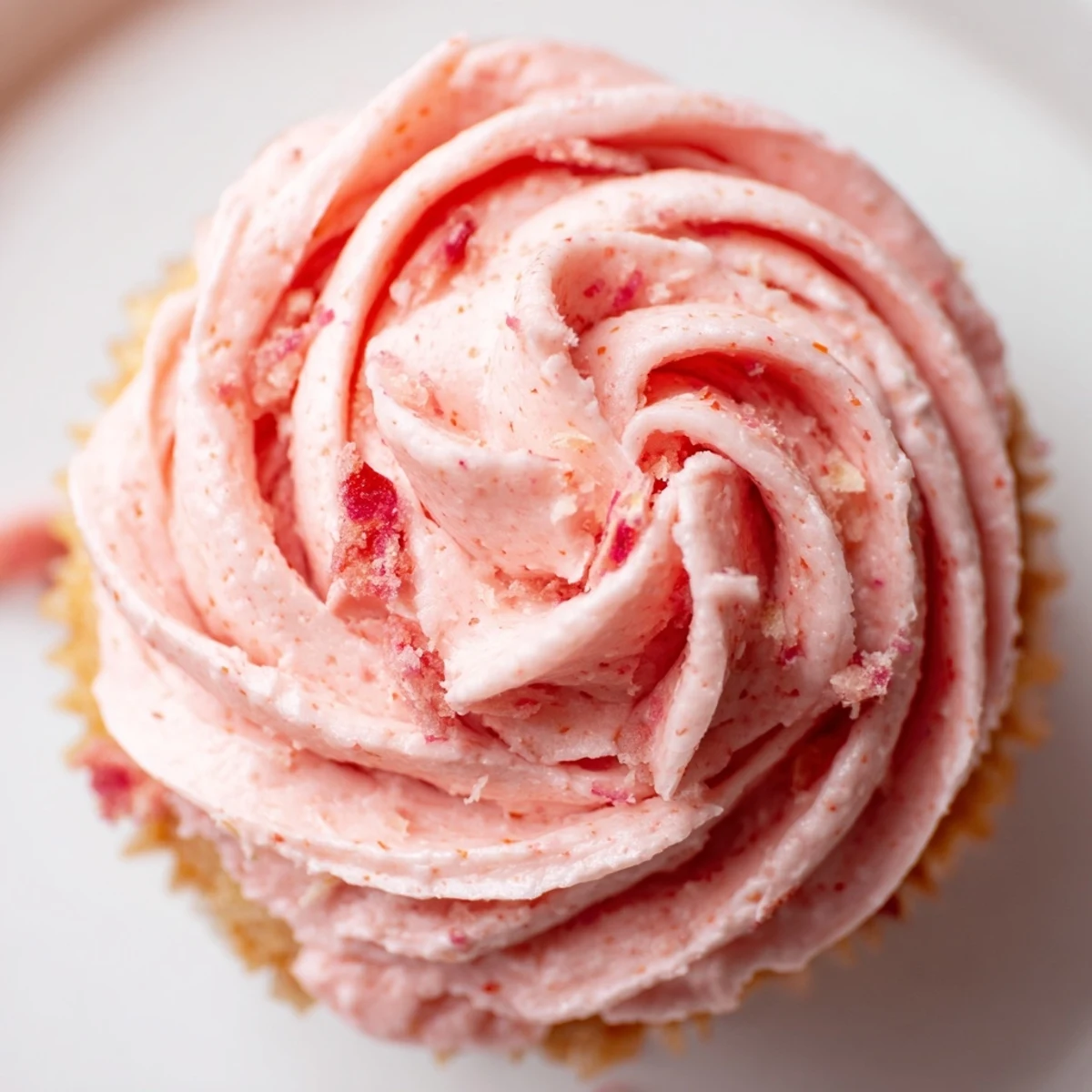 Fresh strawberry lemonade cupcakes with fluffy pink frosting piped high and lemon zest garnish