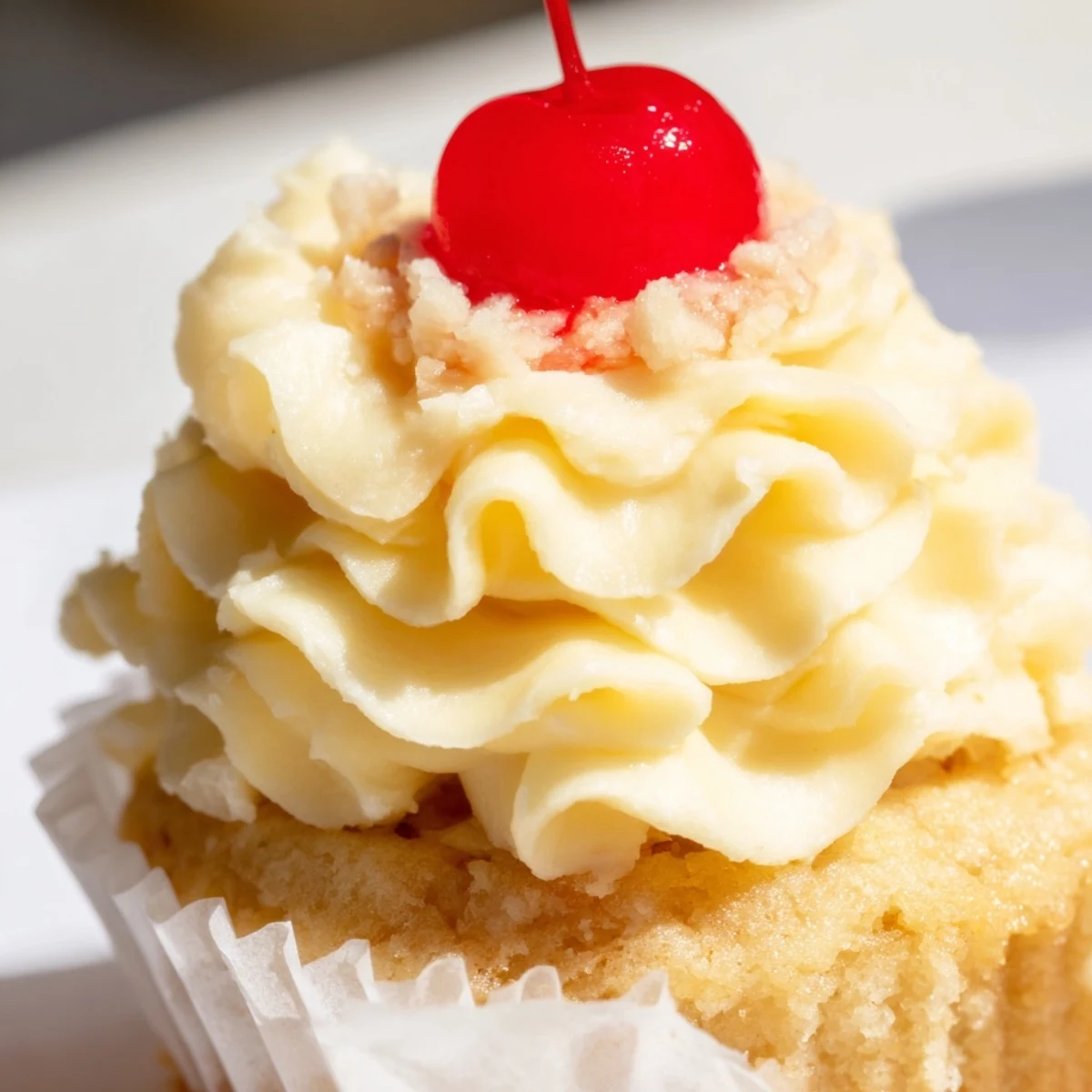 Moist banana milkshake cupcakes topped with creamy vanilla frosting and a bright red maraschino cherry