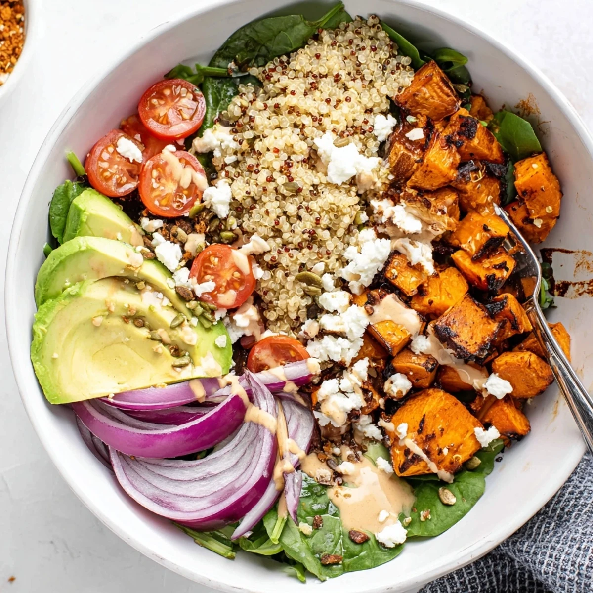 Glistening Roasted Sweet Potato Quinoa Salad Bowl with lemon tahini drizzle and seeds