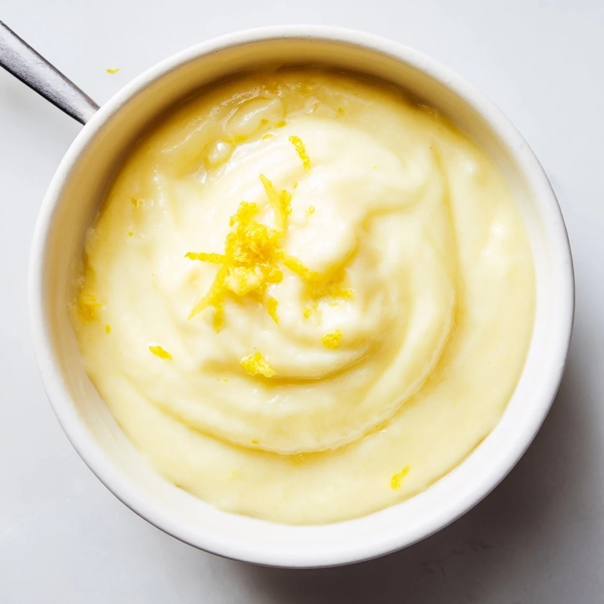 Glossy, tangy Lemon Curd Recipe dolloped on warm buttered scone, with tea