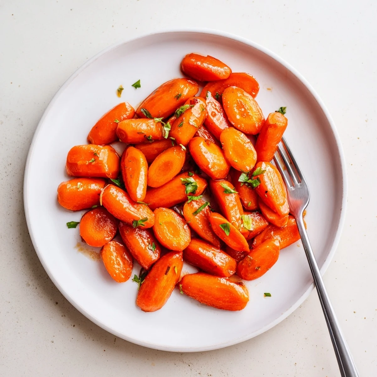 Tender roasted carrots coated in glossy honey caramelized glaze sprinkled with fresh green parsley