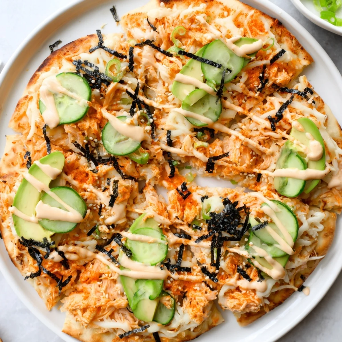Golden baked salmon sushi flatbread pizza topped with creamy avocado slices and crisp cucumber
