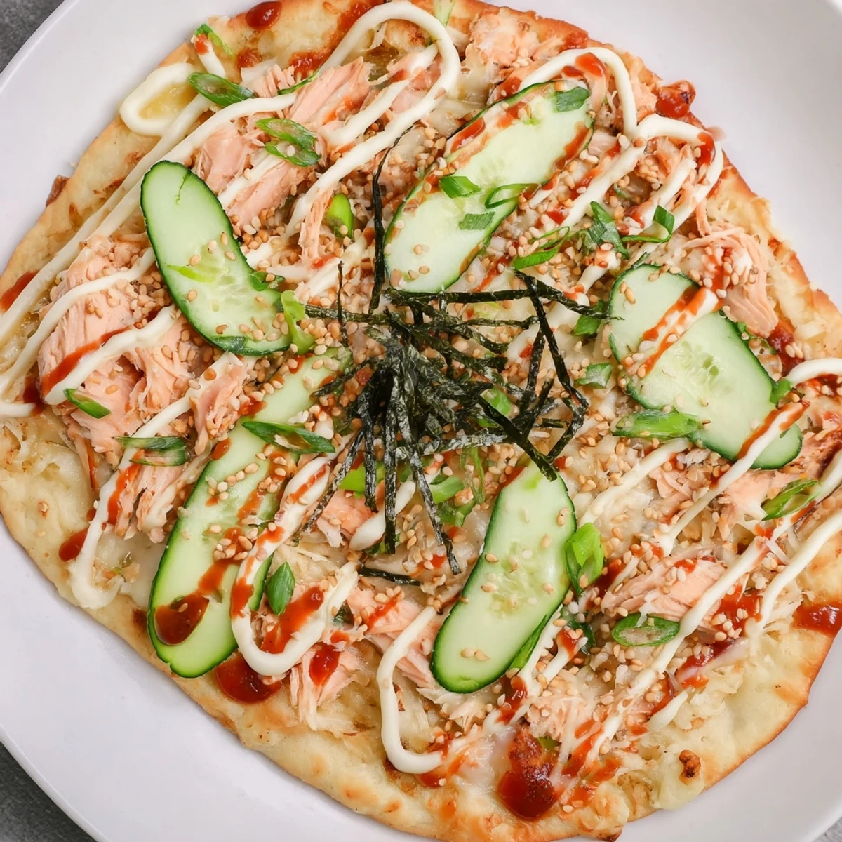 Crispy flatbread layered with salmon sushi rice mixture mozzarella cheese and nori strips