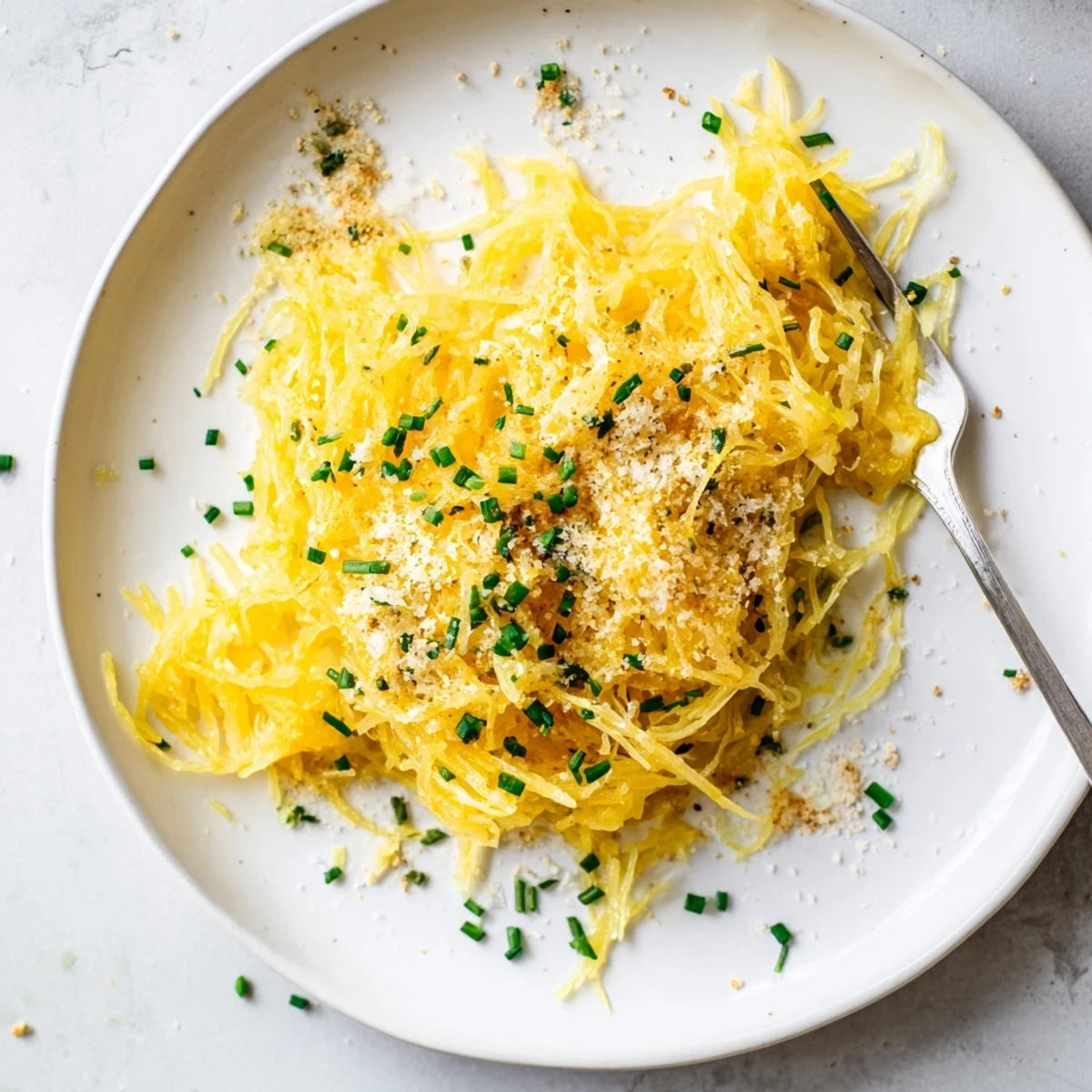 Creamy gluten-free spaghetti squash mac cheese with sharp cheddar and Gruyère sauce in white serving dish
