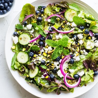 Fresh Blueberry Pistachio Spring Salad drizzled with bright lemon-honey vinaigrette in bowl
