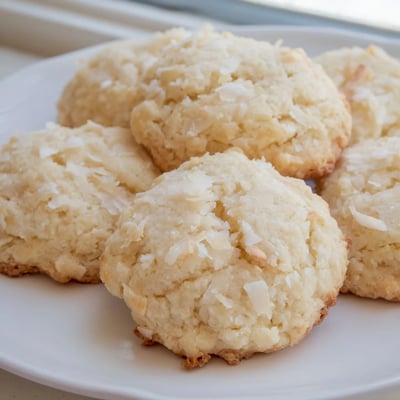 Soft and buttery coconut cookies studded with shredded coconut close-up on parchment